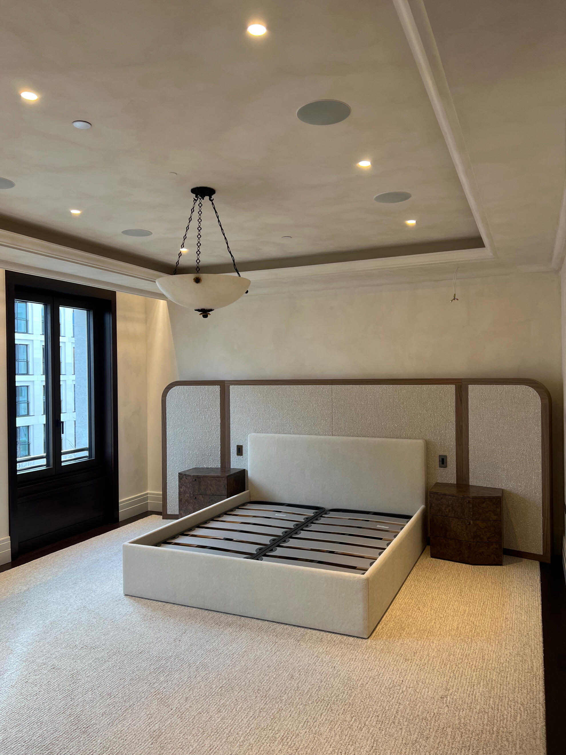 Limewashed bedroom walls and ceiling in a London residential project, pale neutral finish